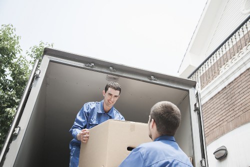 Professional movers handling boxes in a London flat move